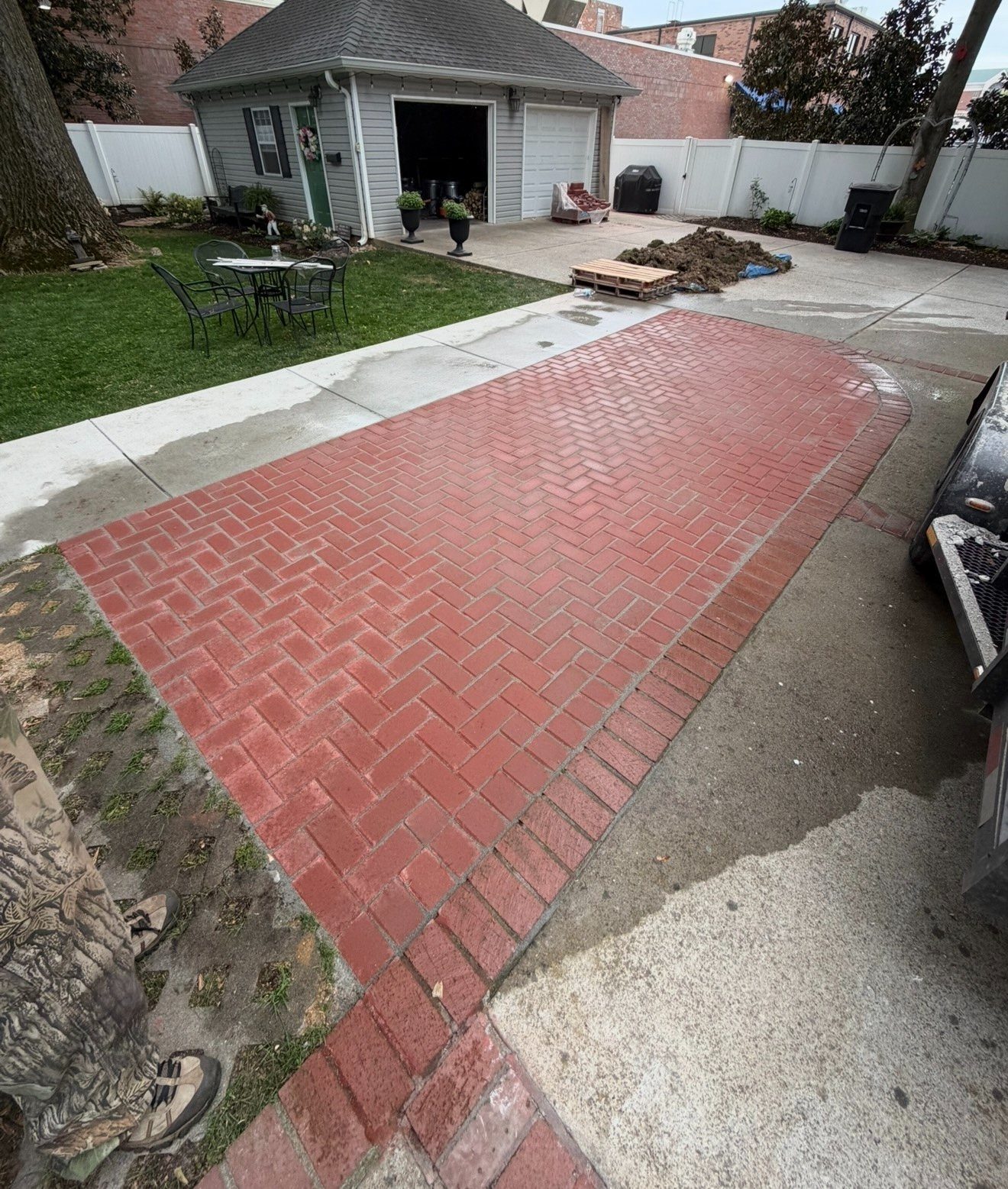 Herringbone brick driveway leading to a detached garage