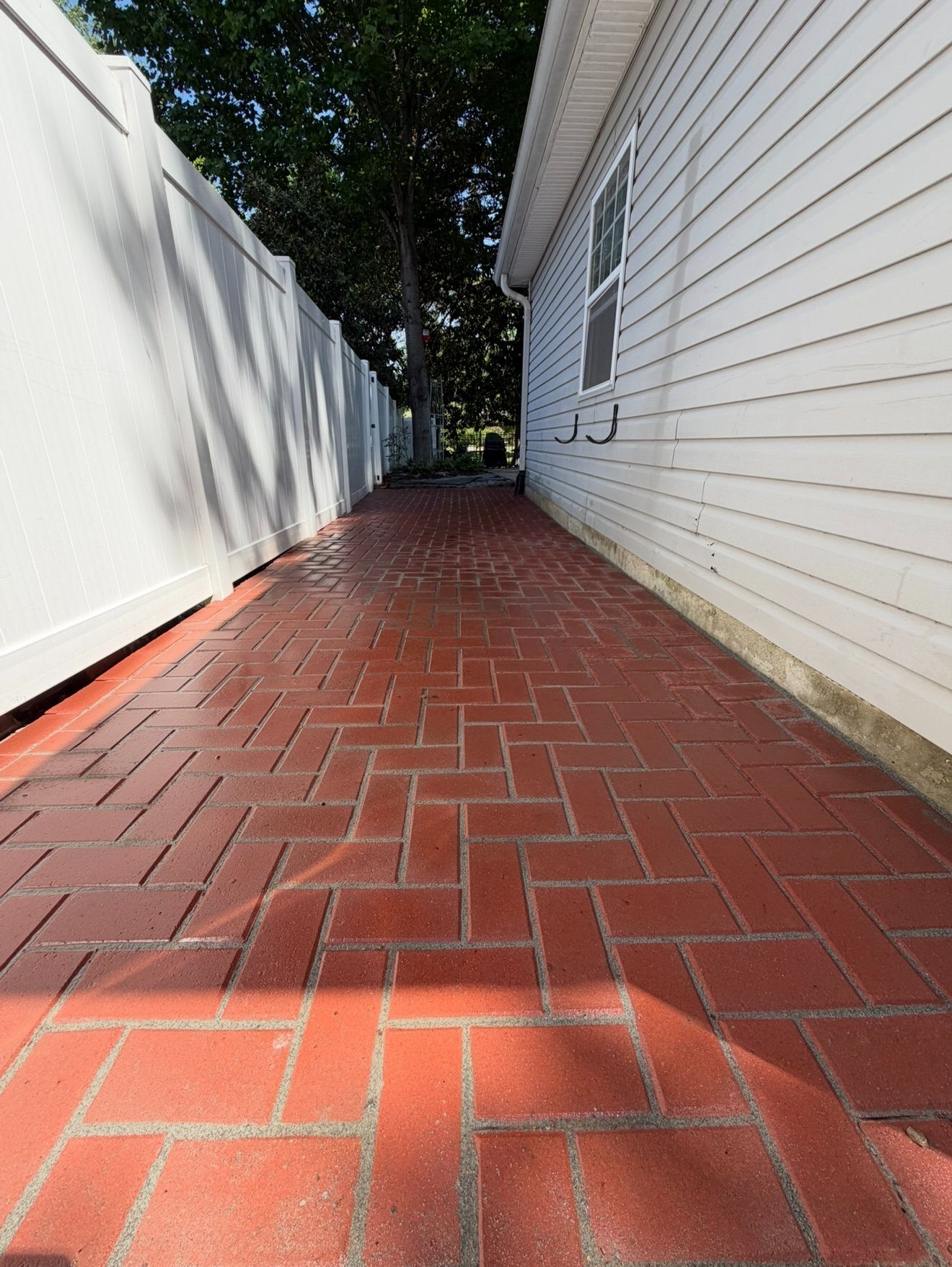 Brick paver side walkway between a home and fence