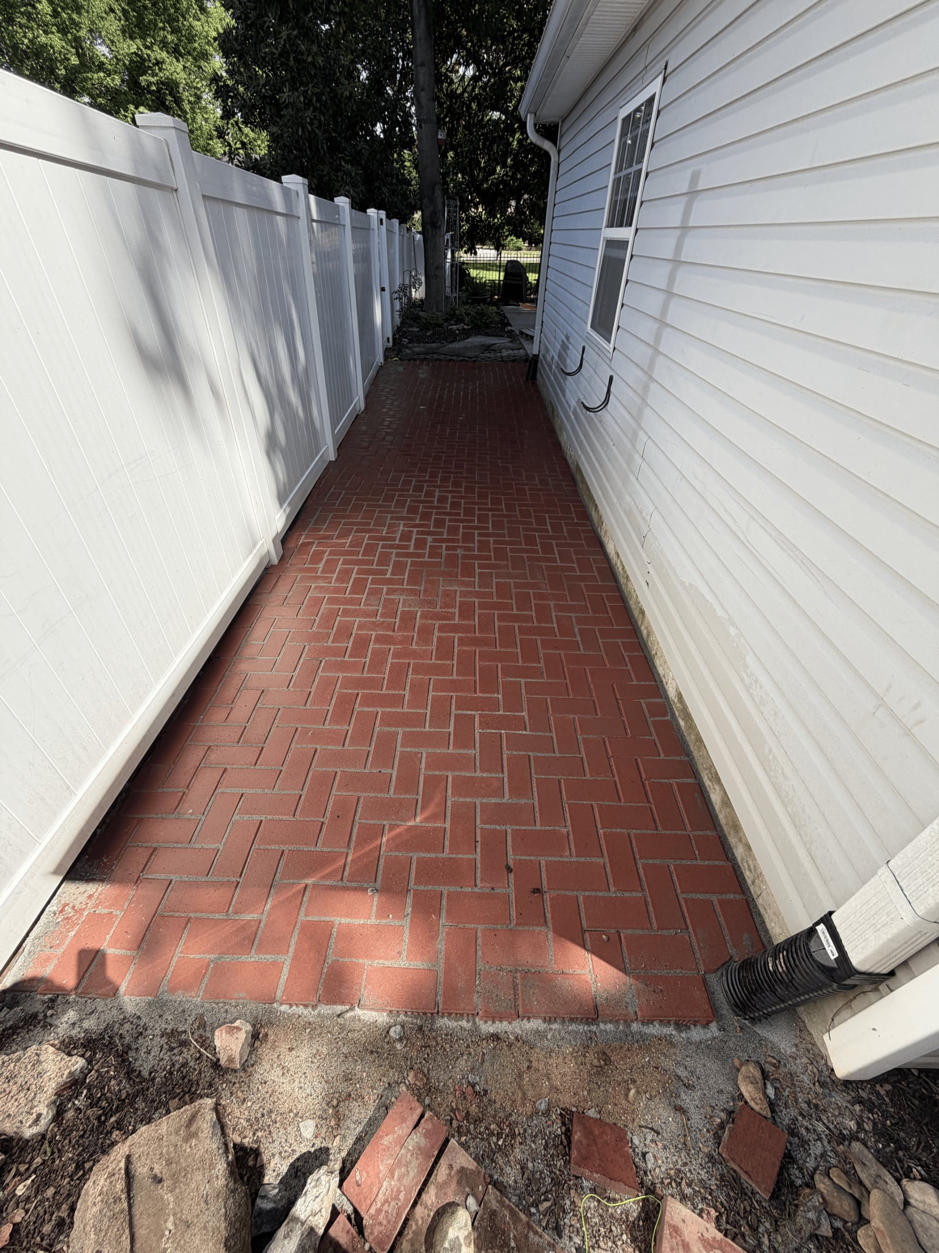 Herringbone brick walkway along the side of a house