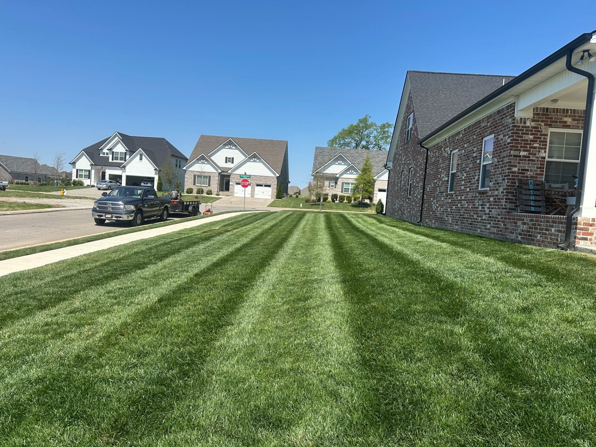 Freshly cut lawn with clean edges along the driveway